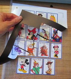 someone is cutting out the numbers from mickey mouse pictures on a sheet of paper with scissors