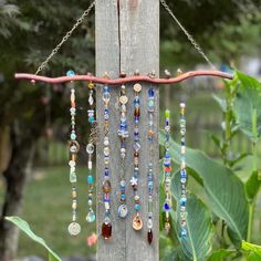 a bunch of beads hanging from the side of a wooden pole