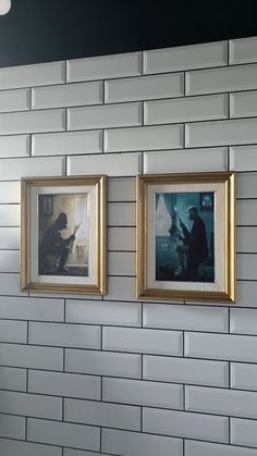 two framed pictures hang on the wall next to each other in a room with white brick walls