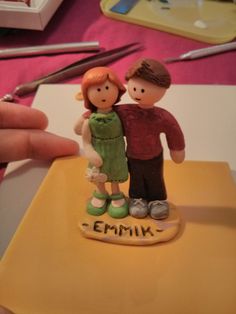 a small figurine of two people standing next to each other on a table