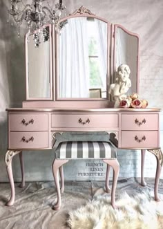 a pink vanity with a bench and mirror