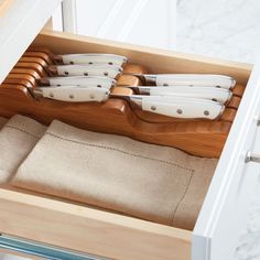 a drawer with knives and napkins in it