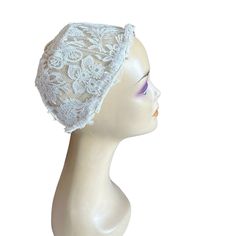 a mannequin head wearing a white lace hat