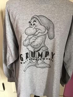 "Vintage 1990's Y2K long sleeve Tee Shirt with *GRUMPY* on it. Gray in color. Made of 90% Cotton and 10% Polyester. Tagged size XL. Go by the measurements below. *MORE INFORMATION BELOW* CONDITION: No issues noted. MEASURES: Chest/Bust~48\" Bottom edge~52\" Sleeve length~21\" Shoulder seam to shoulder seam~23\" Back of collar to bottom~29\" *WE APOLOGIZE~BUT WE NO LONGER SHIP TO GERMANY, ITALY OR SPAIN. IF ORDERS COME IN FROM GERMANY, ITALY OR SPAIN, WE WILL HAVE TO CANCEL THEM AND REFUND YOUR M Winter Long Sleeve Graphic Shirt, Vintage Long Sleeve T-shirt For Winter, Retro Gray Long Sleeve Tops, Retro Long Sleeve Tops With Screen Print, Retro Long Sleeve Pre-shrunk Sweatshirt, Retro Long Sleeve Shirt For Streetwear, 90s Graphic Print Long Sleeve T-shirt, Retro Long Sleeve T-shirt With Screen Print, Vintage Long Sleeve T-shirt With Screen Print