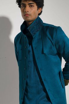 Featuring a teal flap overcoat with abstract hand painted borders at the hem and collar. Blue Shacket, Painted Borders, Jatin Malik, Blouse Yoke, Abstract Motif, Dhoti Pants, Abstract Hand, Tapered Trousers, Indian Wedding Outfits