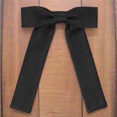 a black bow hanging on the side of a door