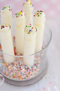 a glass bowl filled with cake batter and sprinkles on top of a table