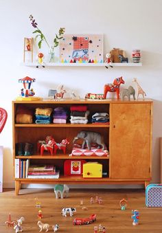 a wooden bookcase filled with lots of toys