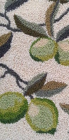 a close up view of a rug with green leaves and flowers on it's surface