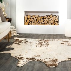 a living room filled with furniture and a fire place covered in lots of wood logs