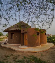 a small building with a thatched roof in the desert