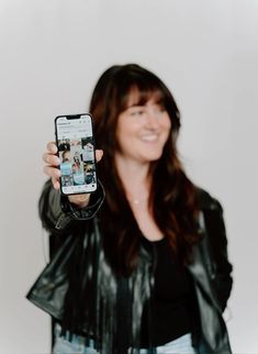 a woman is holding up her cell phone