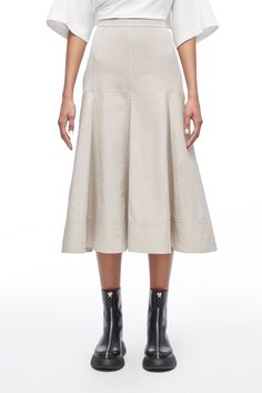 Focused, feminine and versatile is how creative director, Phillip Lim described our knitwear this season. And nowhere is that more apparent than in the viscose knit poplin midi skirt. This elegant A-line has a wide, subtle pleat and mid-calf hemline that imbues a soft femininity and makes it perfect for transitional seasons. Wear it with bare legs and a strappy sandal in late spring and summer, and with the Naomi soft bootie and tights as the weather cools. It is the perfect expression of our ro Chic Cotton A-line Pleated Skirt, Pleated Full Skirt Midi Dress For Work, Chic Midi Dress With Flared Skirt For Work, Chic Flared Midi Dress For Work, Pleated Flared Skirt Midi Dress, Pleated Midi Dress With Voluminous Skirt, Chic Flowy Skirt With Wide Hem, Chic Fall Midi Dress With Full Skirt, Spring A-line Midi Dress With Pleated Skirt