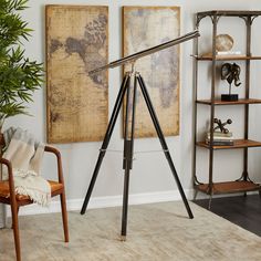 a tripod lamp sitting on top of a wooden floor next to a book shelf