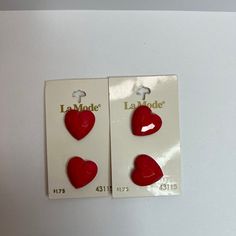 two red heart shaped earrings are shown in front of a white background with the words la modee on it