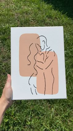 a person holding up a piece of paper with a drawing of a man and woman on it