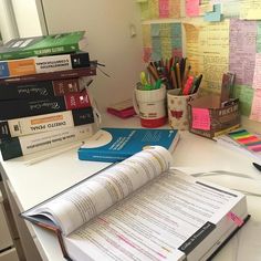 a stack of books sitting on top of a desk next to a pile of papers