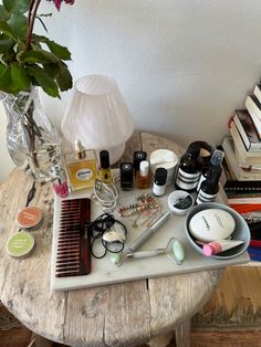 an assortment of beauty products on a table next to a vase with flowers in it