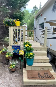 the steps lead up to an rv with flowers and potted plants