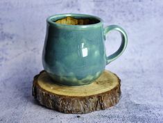 a green cup sitting on top of a wooden stump