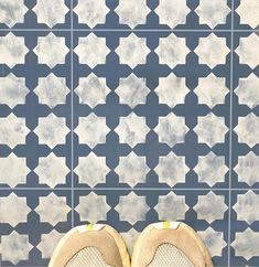 a pair of shoes sitting on top of a tiled floor next to a blue and white wall