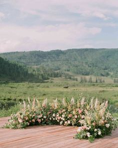 the flowers are arranged on the wooden table