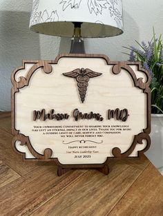 a wooden plaque with a medical symbol on it and a lamp next to it that says,