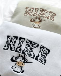 two white towels with black and brown designs on them, one has a monkey in the middle