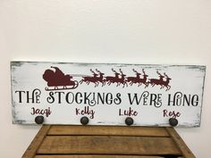 a wooden sign with santa's sleigh and reindeers on it that says the stockings were hung