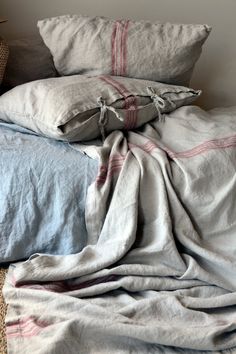 an unmade bed covered in blankets and pillows