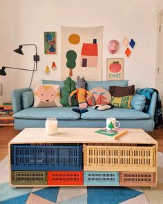 a living room with a blue couch and colorful pillows on the back of it's sofa