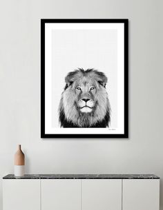 a black and white photo of a lion's face on a wall above a cabinet