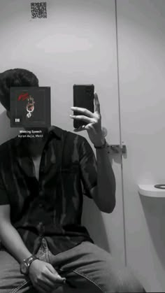 a man taking a selfie in front of a bathroom mirror with his cell phone