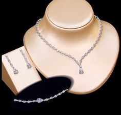 A beautiful three-piece bridal jewelry set that will add elegance and sophistication to any wedding gown or formal ensemble! Adorned with intricately faceted cubic zirconia that capture the light from every angle with a perfectly translucent appeal, the pieces are platinum plated for a flawless finish which enhances the intricate detailing and conveys a modern take on old elegance. Necklace: 17" (approx. 43cm) long with a secure fold-over closure (a 2" extension chain can be added upon request, Elegant Cubic Zirconia Bridal Sets, Elegant Diamond White Bridal Sets With Sparkling Stones, Elegant Crystal Bridal Sets With Rhinestones, Elegant Diamond White Crystal Wedding Accessories, Elegant Cubic Zirconia Bridal Set With Diamond Cut, Elegant Bridal Sets With Rhinestones And Crystal, Elegant Bridal Sets With Sparkling Cubic Zirconia, Elegant Crystal Bridal Sets For Formal Occasion, Elegant Formal Crystal Bridal Sets