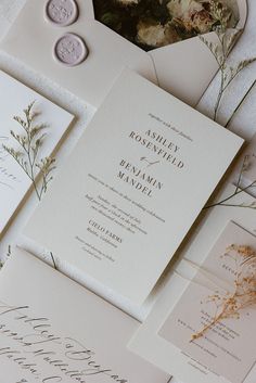 the wedding stationery is laid out on top of each other