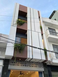 an apartment building with plants on the balconies