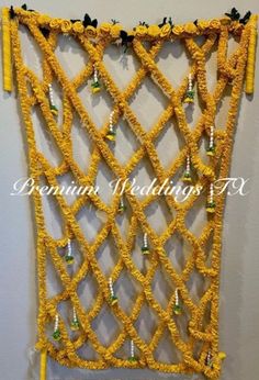 a wall hanging made out of yellow string and plastic bottle caps with beads on it