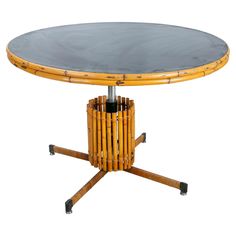 a bamboo table with black top and wheels on the legs, sitting against a white background