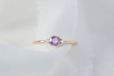 *This listing is for one Freya, purple sapphire + natural white diamonds only* She's finally here! Meet our newest addition to the family - Freya! Made of a natural alluring purple sapphire as a focal stone and accented with 2 sparkling with diamonds flanked on the side in solid 14K yellow gold on our signature fine and delicate band. Specifications: - Solid 14K Yellow Gold (no plating) - 1.2mm (width of band) - 0.25 CT natural purple sapphire, heated, VS clarity - 0.06 CWT natural white diamond Wedding Rings Purple Diamond, Purple Sapphire Ring, Sapphire Wedding Band, Sparkly Ring, Purple Diamond, White Diamond Ring, Purple Sapphire, Purple Band, 925 Silver Jewelry