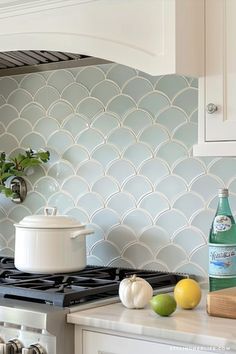 a stove top oven sitting inside of a kitchen next to a pot and lemons