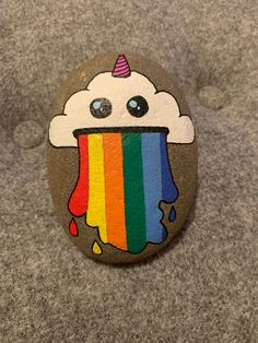 a painted rock with a rainbow ice cream on it