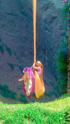 a barbie doll swinging on a rope in front of a mountain and blue sky with purple flowers