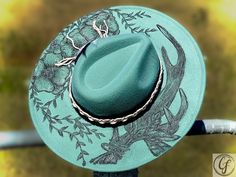 FLORAL ANTLER FEDORA Wide brim. Sea-foam green color custom hand burn fedora. Handmade. Adjustable inside ribbon. Comes as pictured. Item Details: Branded Wide Brim HatsEach hat is hand burned for a custom branded design, because of that each order will vary slightly. Hat band is included in the order. Please feel free to message me with any customization requests. These are quite literally completely customizable. Due to the custom nature of our hats, all purchases are nonreturnable and nonrefu Green Hat Bands For Kentucky Derby, Green Short Brim Felt Hat For Summer, Summer Green Felt Hat With Short Brim, Adjustable Green Felt Hat For Summer, Green Summer Felt Hat With Curved Brim, Green Felt Hat With Curved Brim For Summer, Summer Green Felt Hat With Curved Brim, Green Fedora For Kentucky Derby, Green Western Hats For Spring