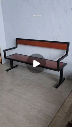 a wooden bench sitting on top of a cement floor