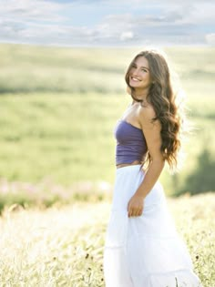 a beautiful young woman standing in a field