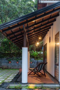 a wooden chair sitting on top of a patio next to a building with lights hanging from it's roof