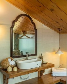 a bathroom sink sitting under a mirror next to a wooden counter