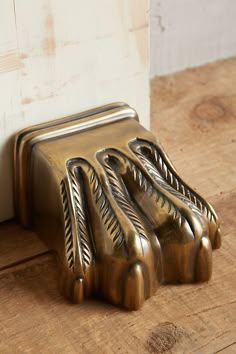 a metal object sitting on top of a wooden floor next to a white door handle