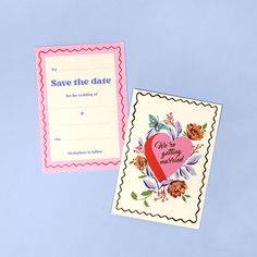 two wedding cards, one with a heart and the other with flowers