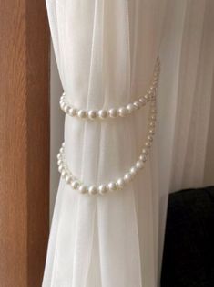 a white curtain with pearls hanging from it